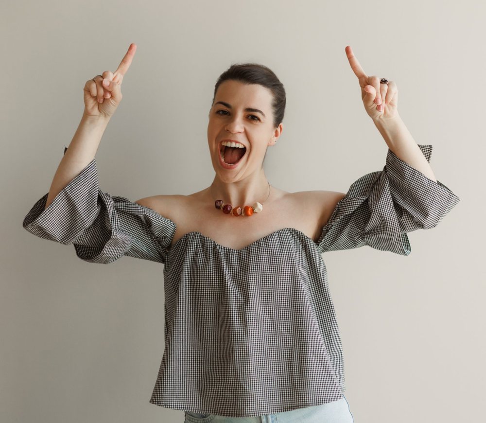 Alexandra smiling and pointing up at the booking options