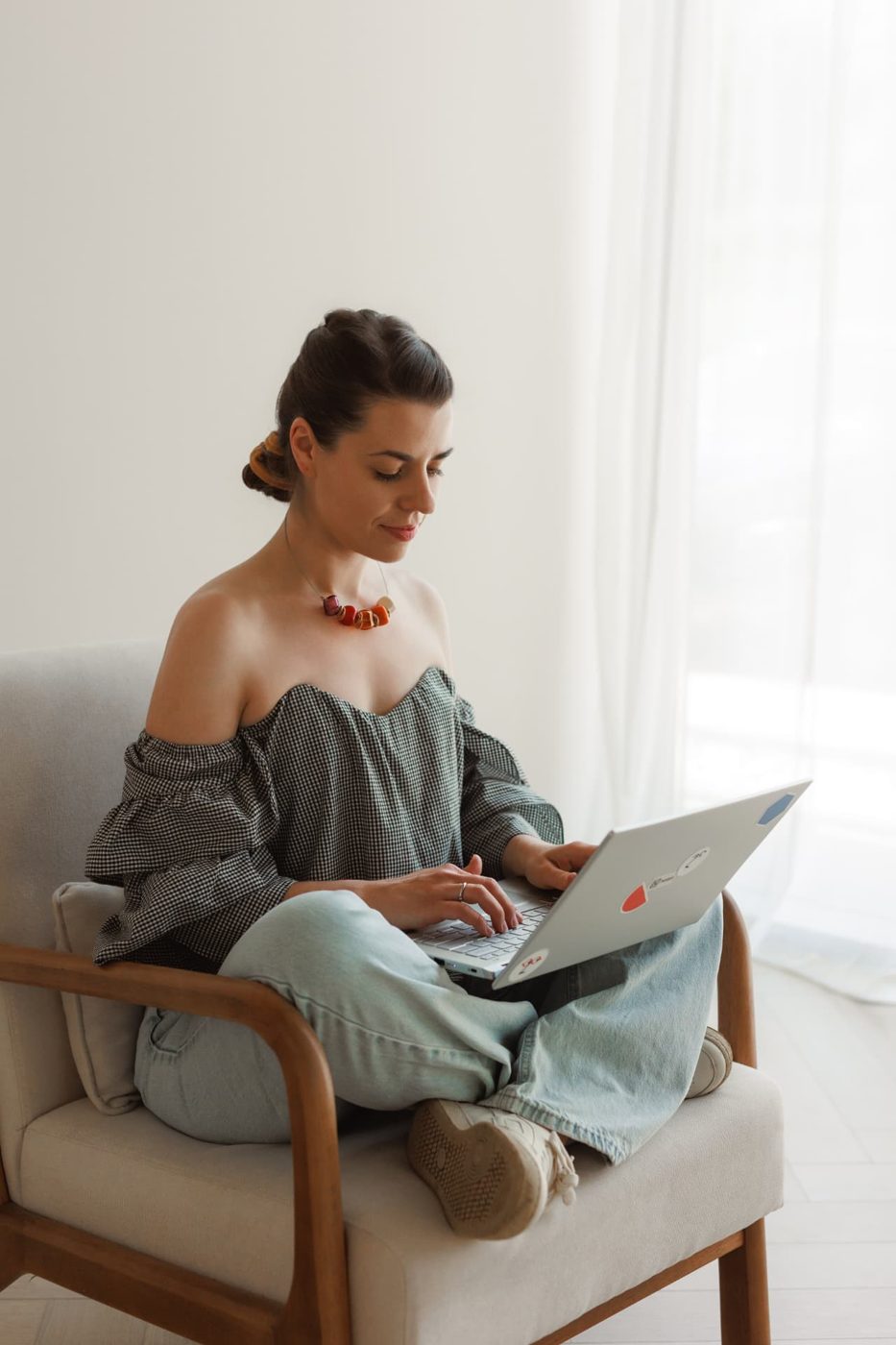 Alexandra working on a laptop in an armchair