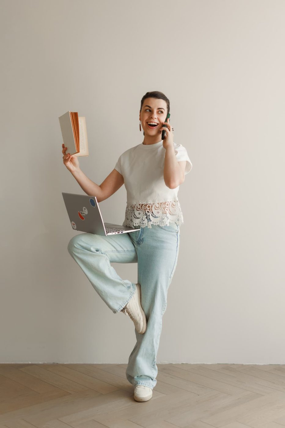 Alexandra standing with a laptop and a book